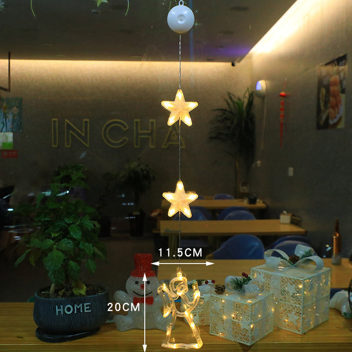 Three warm-white LED star pendants hanging in a window