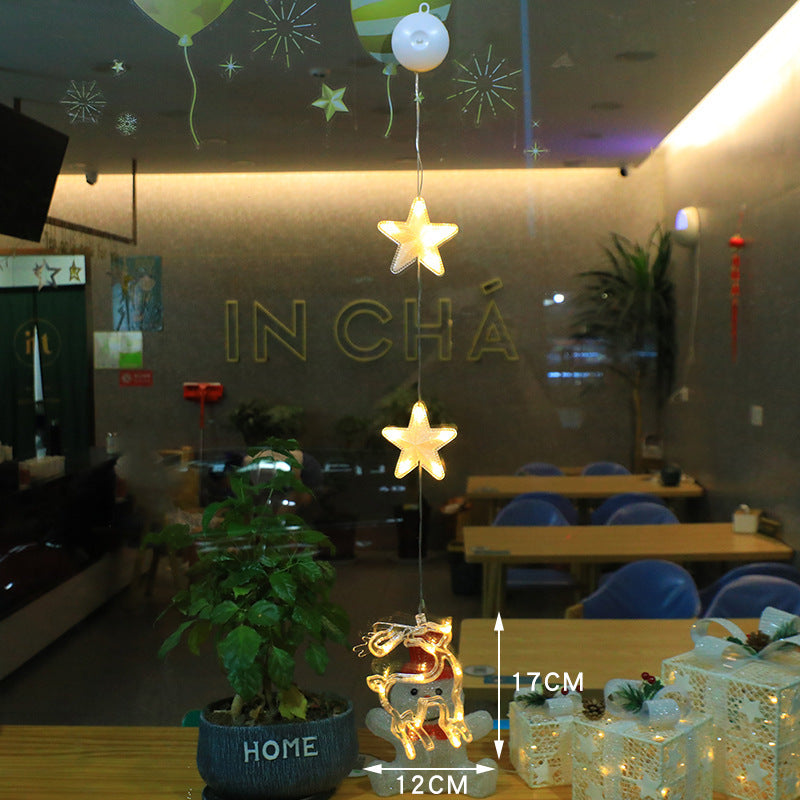 Three warm-white LED star pendants hanging in a window
