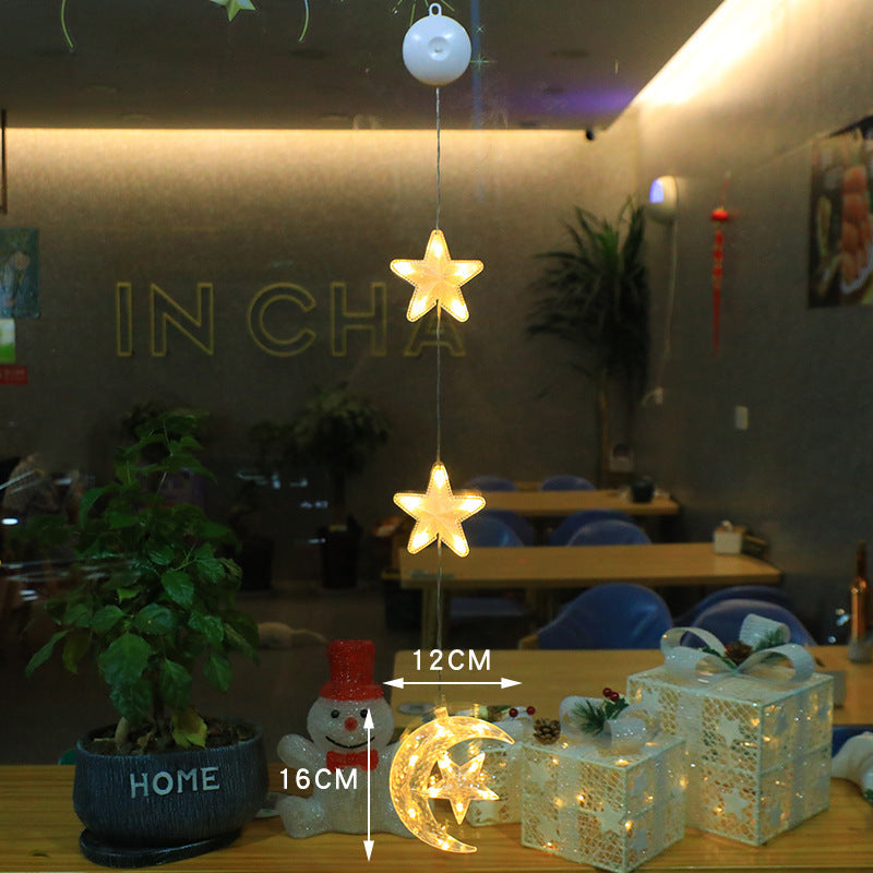 Three warm-white LED star pendants hanging in a window