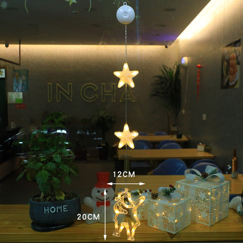 Three warm-white LED star pendants hanging in a window