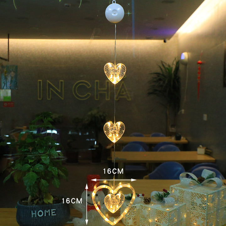 Three warm-white LED star pendants hanging in a window