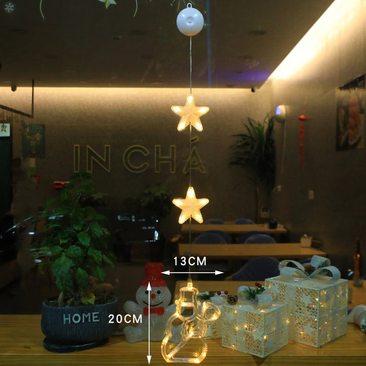 Three warm-white LED star pendants hanging in a window