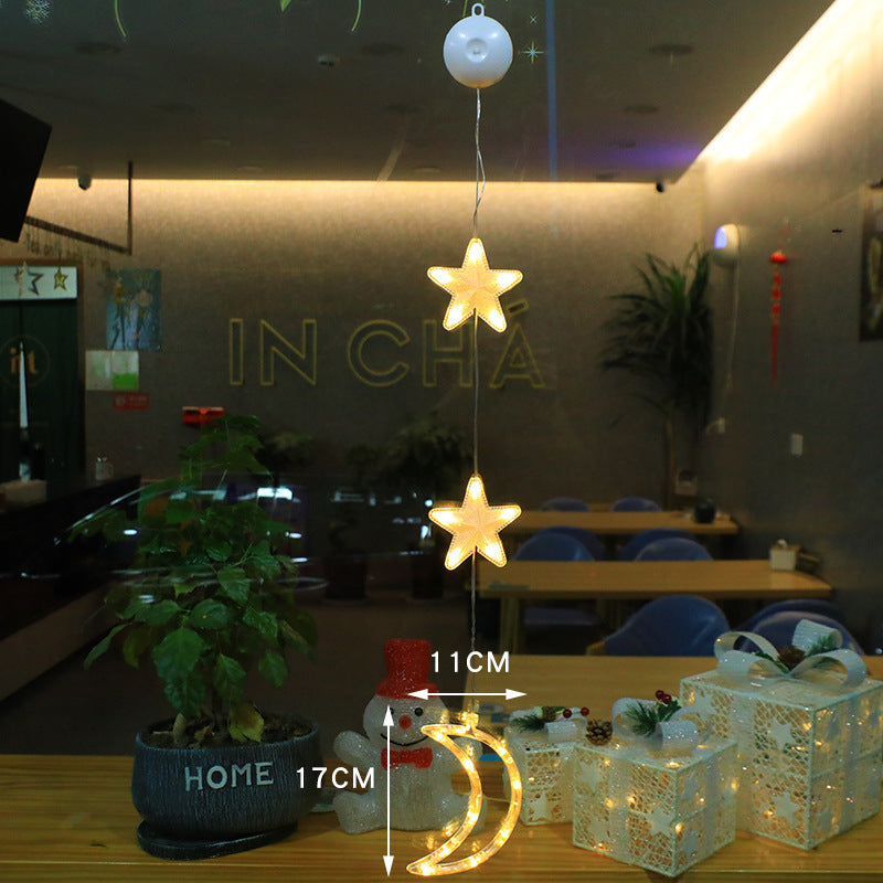 Three warm-white LED star pendants hanging in a window