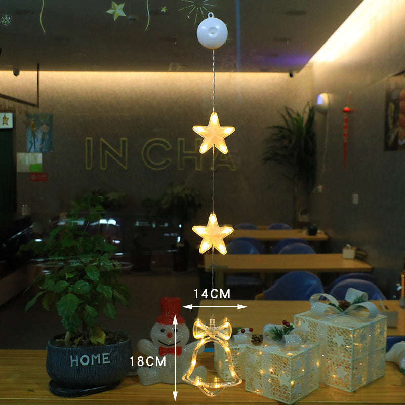 Three warm-white LED star pendants hanging in a window