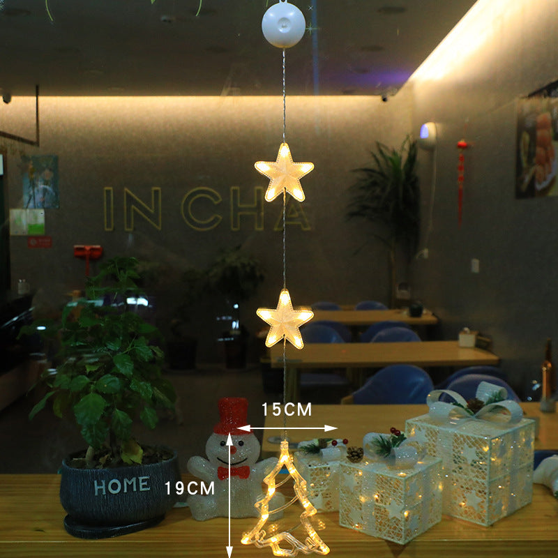 Three warm-white LED star pendants hanging in a window