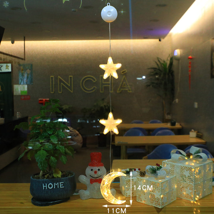 Three warm-white LED star pendants hanging in a window