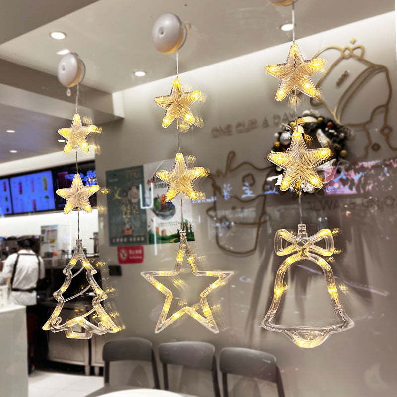 Three warm-white LED star pendants hanging in a window