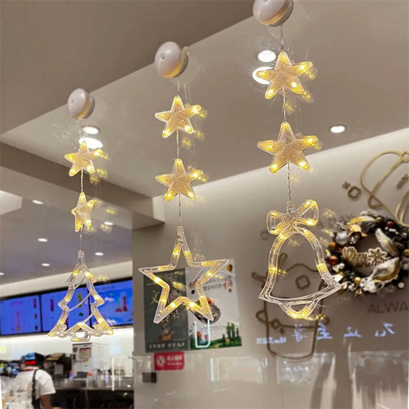 Three warm-white LED star pendants hanging in a window